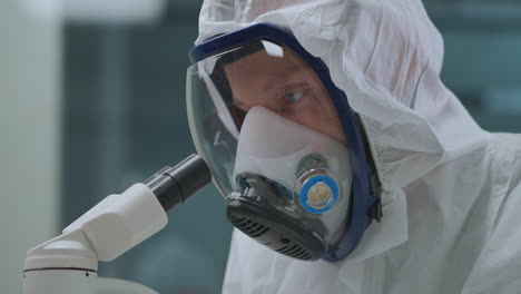 man-is-using-modern-electronic-microscope-for-exploring-bacteria-and-virus-in-laboratory-protective-himself-by-mask-with-respirator-closeup-portrait-of-scientist