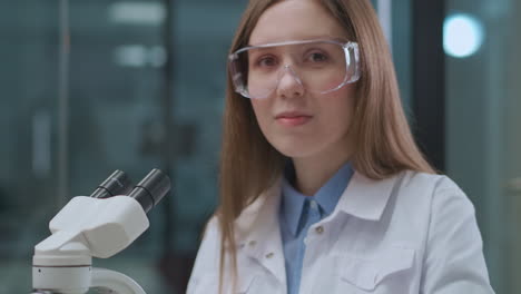 portrait-of-young-woman-working-in-medical-laboratory-exploring-analysis-in-microscope-apparatus-modern-methods-in-medicine-diagnosis