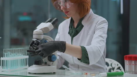 female-professional-technician-of-medical-laboratory-is-working-with-microscope-apparatus-researching-analysis-for-covid-19-pandemic-of-coronavirus