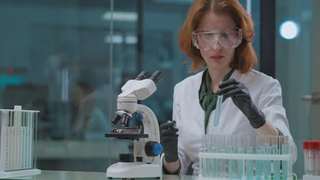 woman-is-working-in-chemical-laboratory-testing-chemicals-by-microscope-scientific-lab-for-experimenting-and-research-portrait-of-female-expert