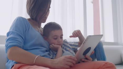 Mother-and-son-playing-with-digital-tablet-at-home.-Young-mother-with-her-5-years-old-smiling-with-digital-tablet-at-home