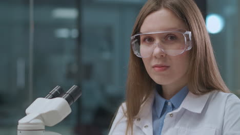 female-expert-of-scientific-laboratory-working-with-microscope-portrait-of-young-woman-in-lab-biology-medicine-and-forensic-expert-practice
