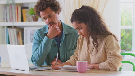 Worried-Young-Couple-In-Debt-At-Home-With-Laptop-Reviewing-Domestic-Finances-Together