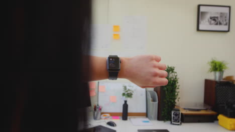 Close-Up-POV-Shot-Of-Female-Office-Worker-At-Desk-Using-Smart-Watch