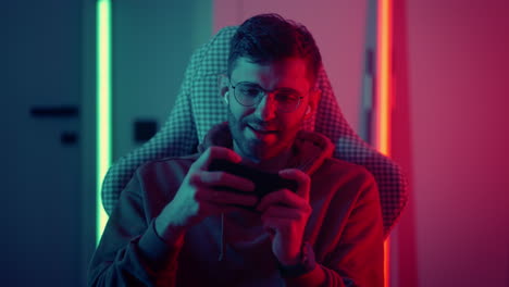 esport-and-video-game-addiction-portrait-of-young-man-playing-mobile-game-by-smartphone-online-streaming-addicted-man-in-game-world-and-virtual-reality-red-and-green-light