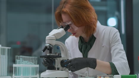 woman-professional-microbiologist-is-researching-analysis-in-laboratory-looking-in-microscope-specialist-of-DNA-analysis-genetic-laboratory-in-university