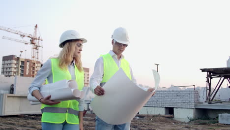 Man-engineer-and-woman-architect-at-a-construction-site.-Building-development-teamwork-and-people-concept.-Man-engineer-and-women-architect-at-a-construction.