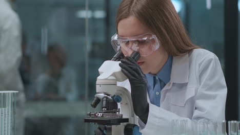 female-doctor-is-exploring-analysis-of-patient-using-microscope-in-laboratory-DNA-blood-and-genetic-engineering-research-medical-lab-with-modern-equipment