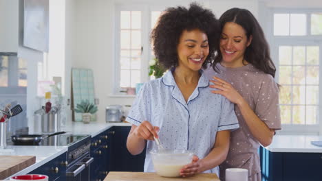 Liebendes-Gleichgeschlechtliches-Weibliches-Paar-Im-Schlafanzug,-Das-Zu-Hause-In-Der-Küche-Morgenpfannkuchen-Zubereitet