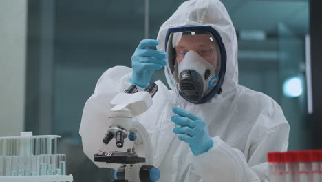 virologist-is-researching-danger-virus-in-laboratory-man-is-dressed-protective-overall-and-face-mask-with-respirator-developing-of-bacteriological-weapon