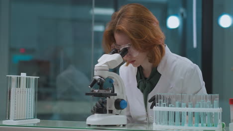 medical-research-of-sample-of-DNK-or-blood-in-crime-lab-female-expert-is-looking-in-microscope-and-exploring-forensic-expert-practice