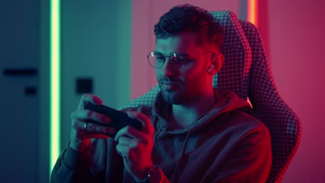 passionate-and-focused-gamer-playing-video-game-in-smartphone-portrait-at-home-in-night-leisure-and-entertainment-esports-and-internet-addiction