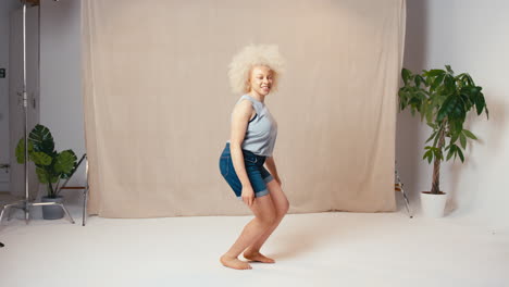 Studioporträtaufnahme-Einer-Lässig-Gekleideten-Körperpositiven-Albinofrau,-Die-In-Die-Luft-Springt