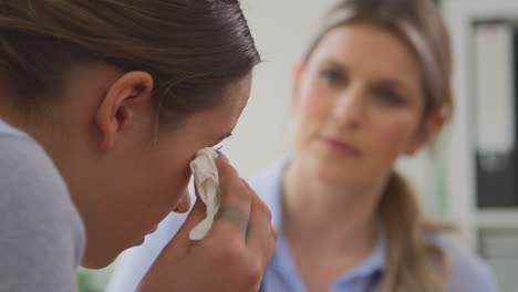 Close-Up-Of-Doctor-Talking-To-Crying-Teenage-Female-Patient-Suffering-With-Mental-Health-Problems