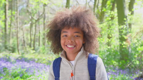 Porträt-Eines-Lächelnden-Jungen,-Der-In-Frühlingswäldern-Mit-Glockenblumen-Spaziert