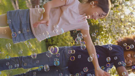 Video-Vertical-De-Un-Niño-Y-Una-Niña-Sonrientes-Al-Aire-Libre-Divirtiéndose-Jugando-Con-Burbujas-En-El-Jardín