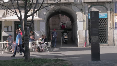 Straßencafé-Auf-Der-Straße-Und-überessender-Lieferbote-Fährt-Roller-In-Lissabon
