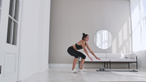 Fitness-woman-doing-burpee-workout-at-home.-Medium-shot-of-young-woman-doing-push-ups-and-jump-exercise-in-slow-motion.-Sport-concept
