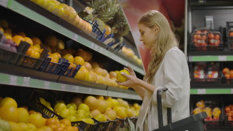 Frau-Wählt-Zitronen-Im-Lebensmittelgeschäft-Aus,-Nimmt-Zitronen-In-Der-Obst--Und-Gemüseabteilung-Eines-Supermarkts