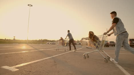 Young-friends-having-fun-on-a-shopping-carts.-Multiethnic-young-people-playing-with-shopping-cart
