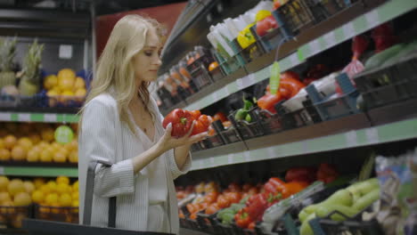 Mujer-Comprando-Pimiento-Rojo-En-El-Supermercado.-Mano-Femenina-Eligiendo-Verduras-Orgánicas-En-La-Tienda-De-Comestibles.-Concepto-De-Compras-Sin-Desperdicio-Y-Estilo-De-Vida-Saludable.-Camara-Lenta
