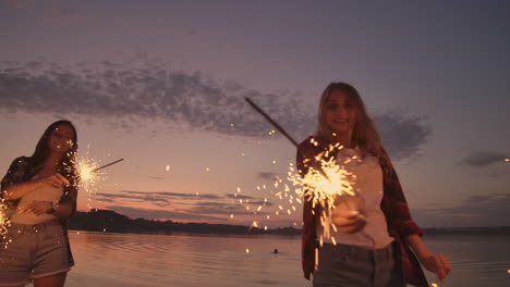 Beautiful-women-in-summer-with-sparklers-dancing-in-slow-motion-on-the-beach-at-night