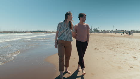 A-happy-couple-walking-down-the-beach-barefoot-holding-hands