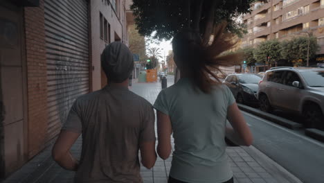 A-back-view-of-a-couple-jogging-along-the-paved-sidewalk