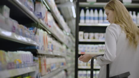 Mujer-Eligiendo-Y-Comprando-Productos-Lácteos-Orgánicos-Frescos-En-La-Tienda-De-Comestibles.