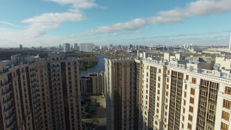 An-aerial-view-of-a-large-modern-residential-building-and-a-sunny-urbanscape-behind-it