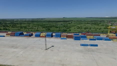 Containers-stacked-at-storage-area-with-gantry-crane-aerial-view