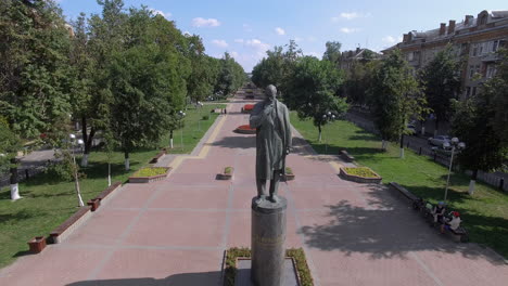 Aerial-summer-scene-of-Russian-town-with-monument-on-tree-lined-avenue
