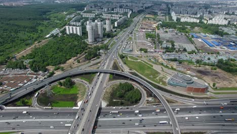 An-aerial-view-of-a-huge-and-busy-road-junction-in-the-middle-of-the-green-urbanscape