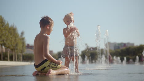 Kinder-Spielen-Mit-Springbrunnen,-Um-Sich-In-Der-Hitze-Abzukühlen
