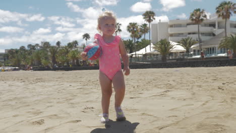 Süßes-Kleines-Mädchen-Im-Rosafarbenen-Badeanzug,-Das-Am-Strand-Spaziert