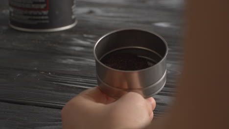 Woman-filling-the-funnel-of-moka-pot-with-ground-coffee
