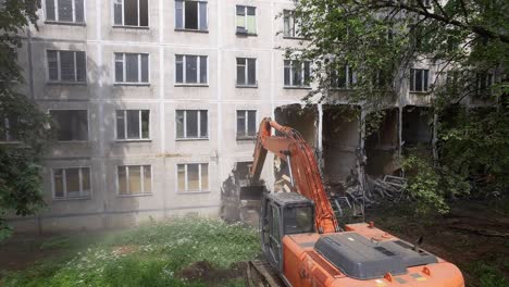 Excavator-pulling-down-old-panel-apartment-house