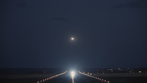 A-night-view-of-a-runway-with-a-taking-off-plane