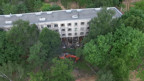 An-aerial-view-of-a-half-demolished-building-among-green-trees