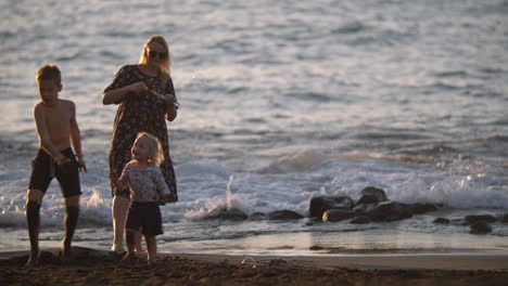 Mum-with-playful-children-on-the-black-sand-beach-Family-vacation