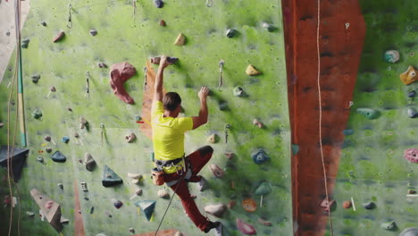 Climbing-sport-activity-concept:-Man-climber-on-wall.-Indoor-climbing-sport-activity-concept:-man-climber-on-artificial-climbing-wall.