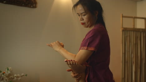 Medicina-China-Alternativa-Una-Mujer-Asiática-Realiza-Un-Masaje-Terapéutico-En-La-Espalda-Y-Las-Piernas-De-Una-Mujer-Caucásica-Tumbada-En-Un-Sofá.-Aromaterapia-Y-Terapia-Manual-Por-Maestros-Chinos.