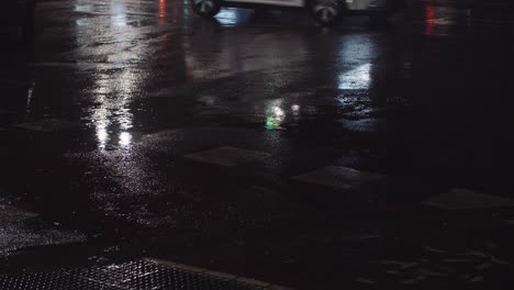 Wet-road-with-cars-passing-by-night-view