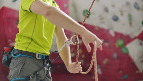 Man-belaying-another-climber-with-rope.-Top-view-of-young-athletic-man-belaying-and-watching-another-climber-with-rope.-Summer-time.-Climbing-equipment.