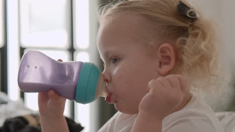 Toddler-girl-drinking-milk-from-the-bottle