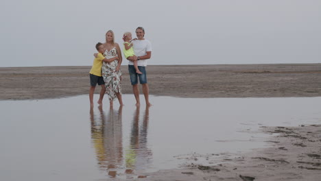 Family-portrait-on-the-beach-Parents-with-two-lovely-kids