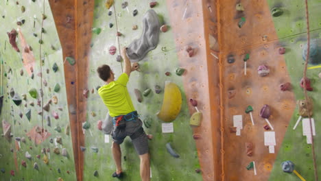 Climbing-sport-activity-concept:-Man-climber-on-wall.-Indoor-climbing-sport-activity-concept:-man-climber-on-artificial-climbing-wall.