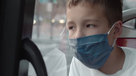 Kid-in-face-mask-traveling-by-bus