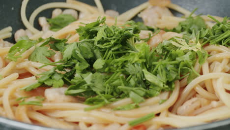 Adding-parsley-to-the-pasta-dish-with-shrimps