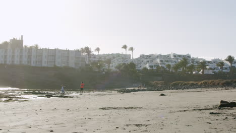 Junge-Ist-Eine-Steinwerfer-Strandszene-Mit-Hotels-Auf-Lanzarote
